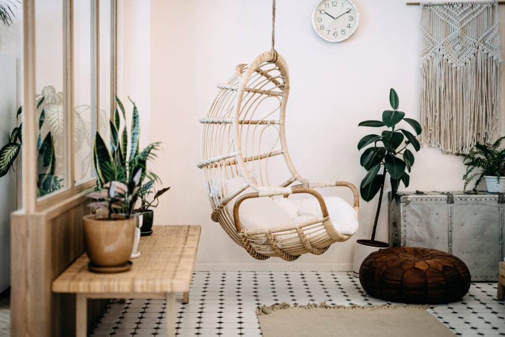 Chaise suspendue confortable dans le salon loft au design élégant et bohème. Bien conçu et décoré avec un assortiment de plantes intéressantes.