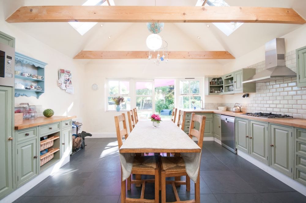 Belle cuisine et salle à manger avec des meubles vert sauge