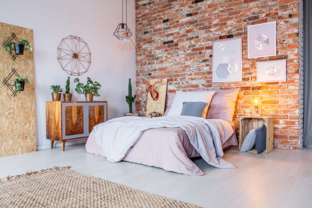 Chambre à coucher lumineuse avec lit double, mur de briques et tapis